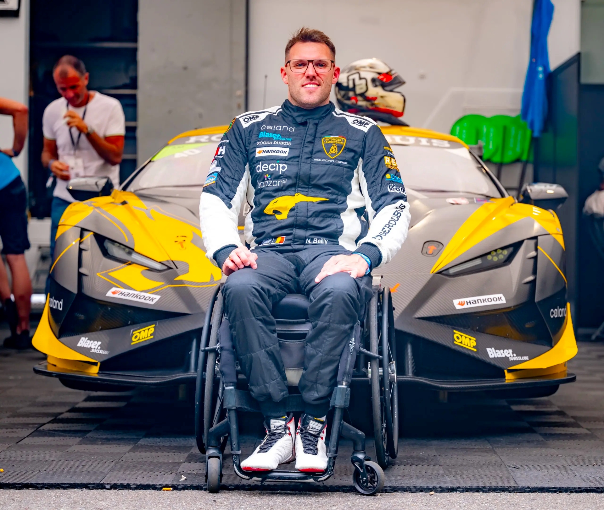 Niguel Bailly souriant devant son véhicule de course
