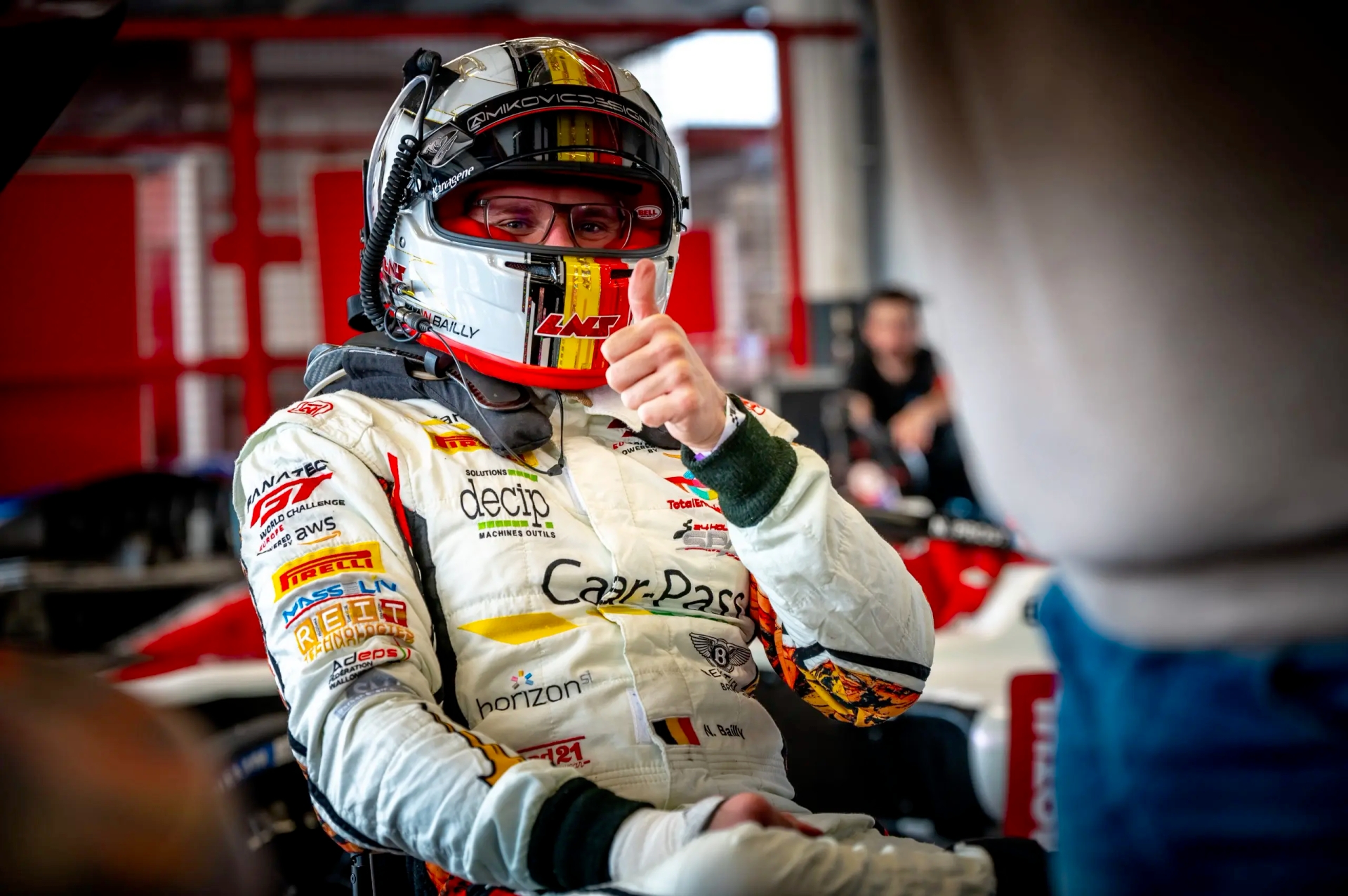 Niguel Bailly vêtu de sa combinaison de course fait un pouce vers le haut.